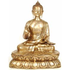 a golden buddha statue sitting on top of a white surface