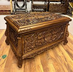 an ornate wooden box sitting on top of a hard wood floor