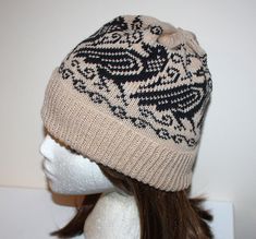 a white mannequin head wearing a hat with black and beige designs on it