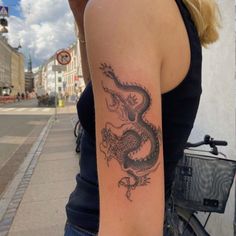 a woman with a dragon tattoo on her arm