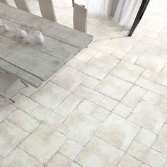 a table and chairs are sitting on a tile floor