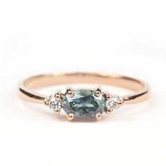 a blue diamond ring with three diamonds on the side and one stone in the middle