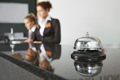 a bell sitting on top of a counter next to a woman in a business suit