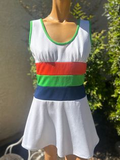 Here is a vintage 1970s white Polyester Tennis Dress. Following are the measurements. Bust 36",Waist 30",Hips full,Length measured from top of shoulder to hem 31".Zips up the back.Waist is green,navy blue,& red stripe waist.In nice vintage condition. Please take special consideration of measurements. 1970 sizing was much smaller than today's standards. Take extra special note of length. Tennis dresss were very short not like a regular dress.If you live overseas please email me first before purch 1970s Fitted White Dress, Fitted White 1970s Dress, White Fitted 1970s Style Dress, White 1970s Fitted Dress, Tennis Dresses, Vintage Tennis, Womens Sports, Tennis Dress, Red Stripe