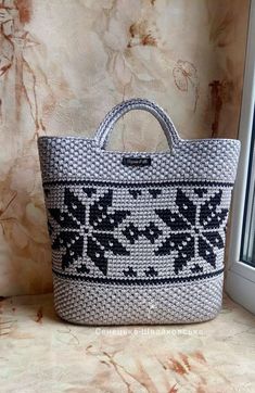 a white and black bag sitting on top of a window sill next to a wall