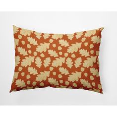 an orange pillow with yellow leaves on it