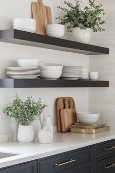 the shelves in this kitchen are filled with plates, bowls and cutting board's