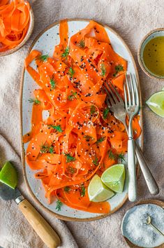 a plate with carrots, lime and seasoning on it next to bowls of dipping sauce