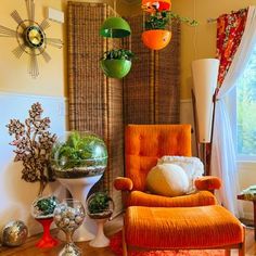 an orange chair sitting in front of a window filled with potted plants and other decorations