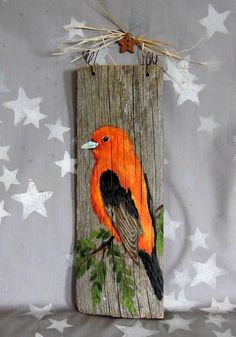 an orange bird painted on wood with stars