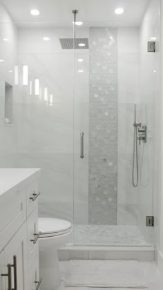 a white bathroom with a walk in shower next to a toilet and bathtub area