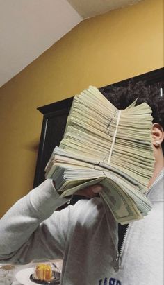 a man holding up stacks of money in front of his face