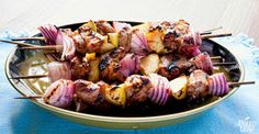 meat and vegetable kabobs on skewers in a bowl, ready to be eaten