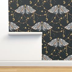 the wall paper is decorated with gold stars and crescents, hanging from chains on strings