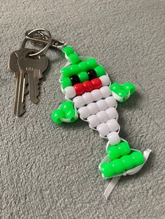 a keychain made to look like an alien with green, white and red beads