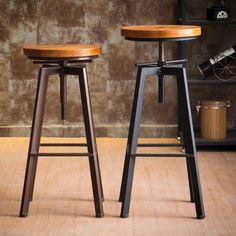 two wooden stools sitting next to each other in front of a book shelf with books on it