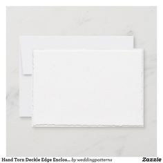 two pieces of white paper with torn edges on the bottom, and one piece of white paper in the middle