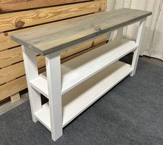 a white wooden table with shelves in front of it