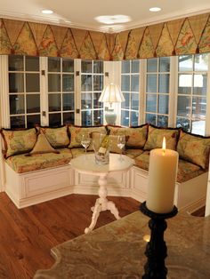 a living room filled with lots of furniture and a candle on top of a table