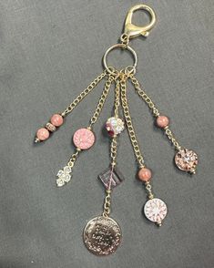 a keychain with various charms hanging from it's sides on a gray surface