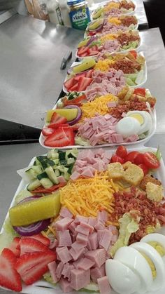 several plates with different types of food lined up on a table in a restaurant or cafeteria