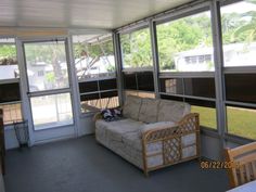 a living room filled with furniture and lots of glass doors on the side of it