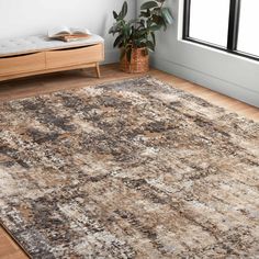 a large area rug in a room with wooden flooring and white walls, along with a window