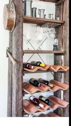 an old wooden shelf with wine bottles and glasses on it