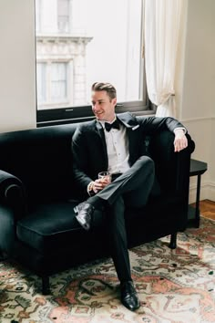 a man in a tuxedo sitting on a couch