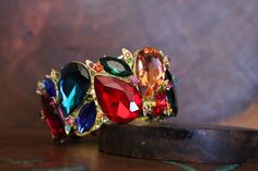 "Beautiful bracelet with large multi color marquise crystals, great statement piece! Pageant, prom, or bridal! Size: 2\" wide Style: stretch bracelet color: fuchsia/yellow/ emerald green/ purple/ aqua, multi colors Base metal color: gold Looking for matching earrings? Browse through our listings or send us a message! :) https://www.etsy.com/listing/538912077/fuschia-large-crystal-earrings?ref=shop_home_active_21&crt=1 https://www.etsy.com/listing/623725360/multi-color-earrings-multi-color?re Hot Pink Bracelets, Valentines Bracelets, Yellow Bracelet, Multicolor Earrings, Color Earrings, Large Crystal, Color Fuchsia, Bridal Bracelet, Rhinestone Bracelet