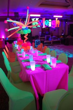 the tables are set up for a party with neon lights and decorations on top of them