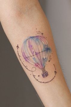 a colorful hot air balloon tattoo on the arm