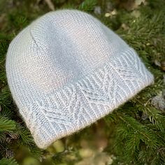 a white knitted hat sitting on top of a tree