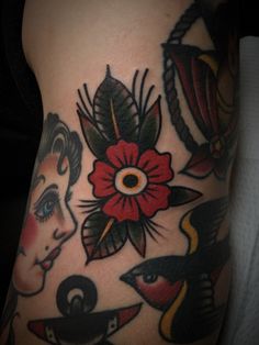 a woman's leg with tattoos and flowers on it