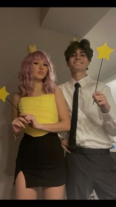 a man and woman dressed up as stars with wands in their hands, standing next to each other