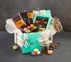 a gift box filled with assorted chocolates and candies next to coffee beans