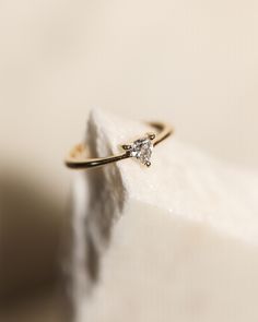 a diamond ring sitting on top of a white piece of cloth