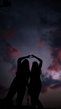 two women standing in front of a night sky