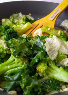 broccoli and cauliflower are being cooked in a wok