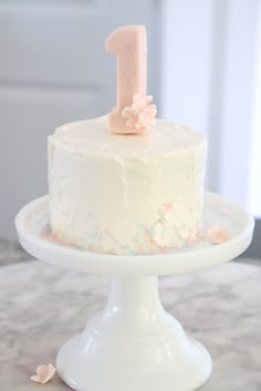 a white cake with pink frosting and a number one on top that says sugar free smash cake recipe