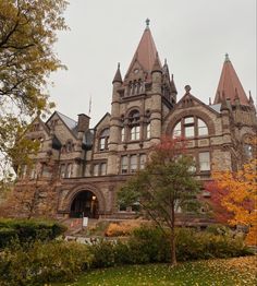 an old building with many windows and towers on it's sides in the fall