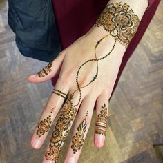 a woman's hand with henna tattoos on it