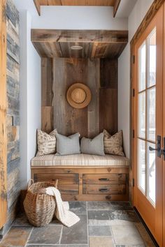 a wooden bench sitting next to a door with pillows on it's backrest