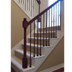 a stair case with iron railing and wood baluster on the bottom handrail