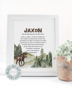 a moose is standing next to a potted plant and a framed print that says, ajaxon