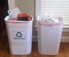 two trash cans sitting next to each other with the words recycle written on them