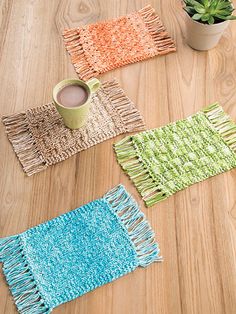 four woven placemats on a wooden table with a cup of coffee in the middle