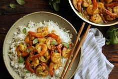 a bowl filled with shrimp and rice next to chopsticks on a wooden table