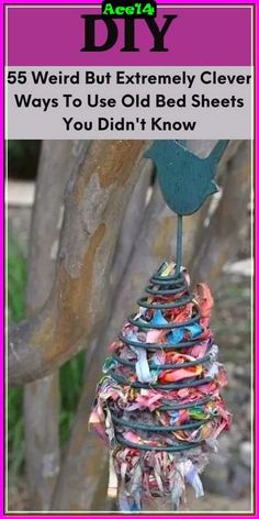 a bird sitting on top of a tree next to a pile of old bed sheets