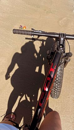 the shadow of a person riding a bike with a bicycle rack on it's handlebars